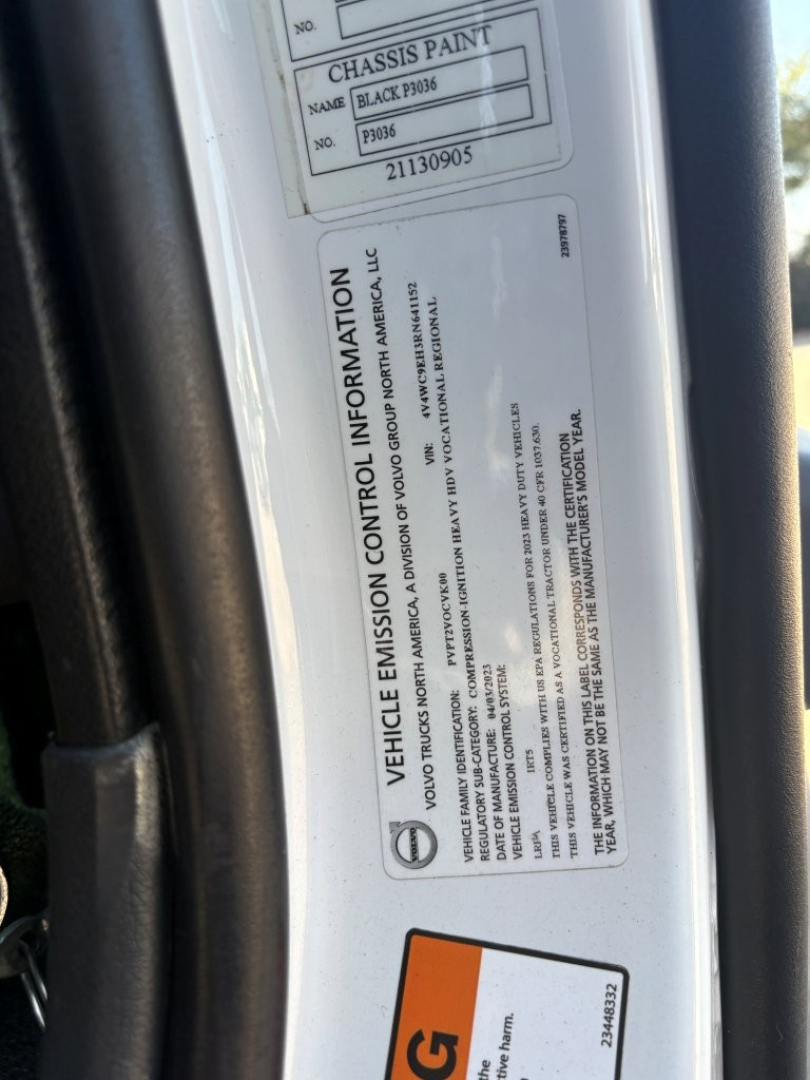 Vehicle information sticker on Volvo VNR64T660 showing chassis paint, VIN, and emission control details.