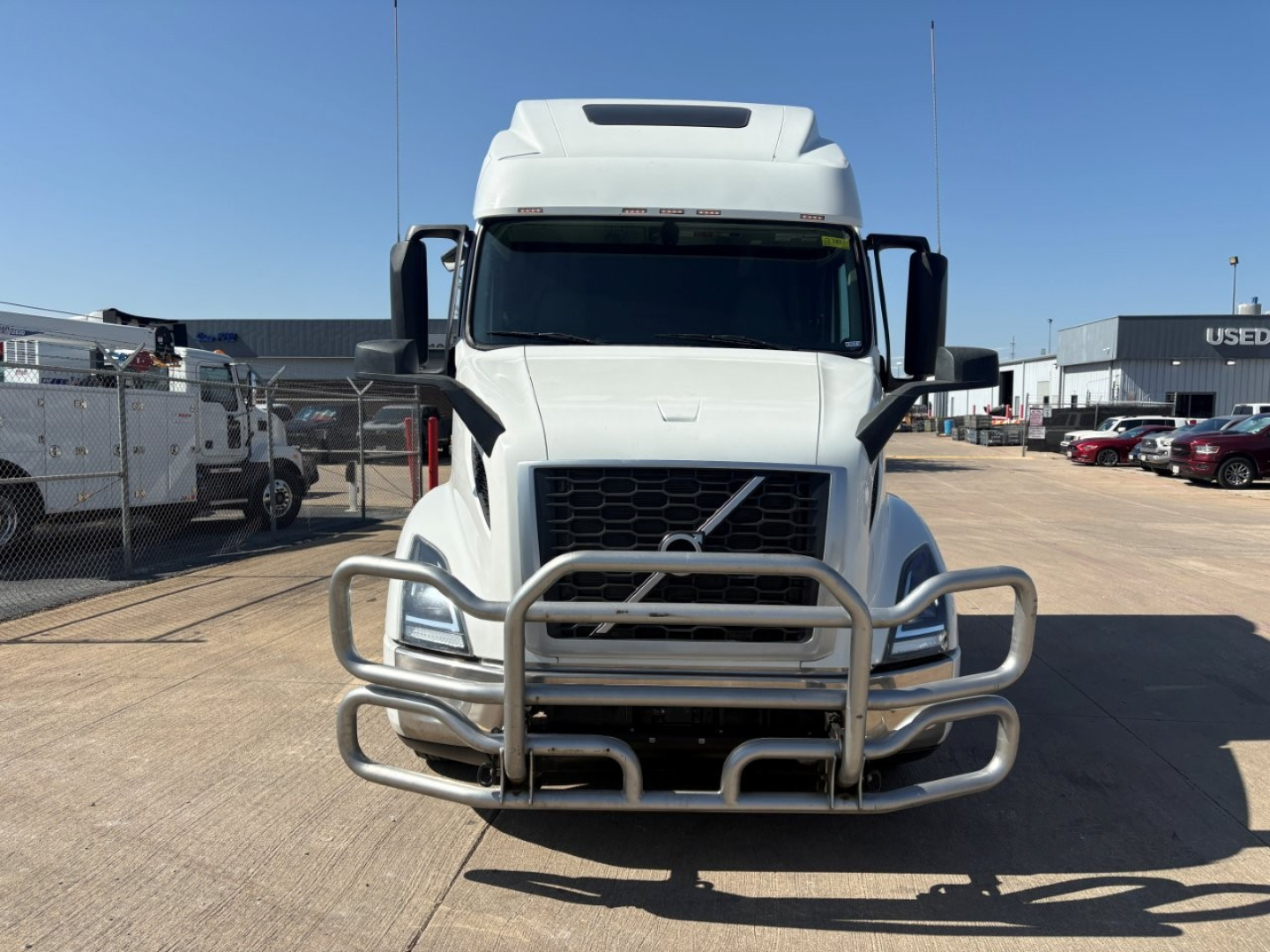 Front view of a Volvo VNR64T660 cab-over truck with a large metal bumper guard. grille and Volvo logo visible; no legible small text visible on the truck in front.