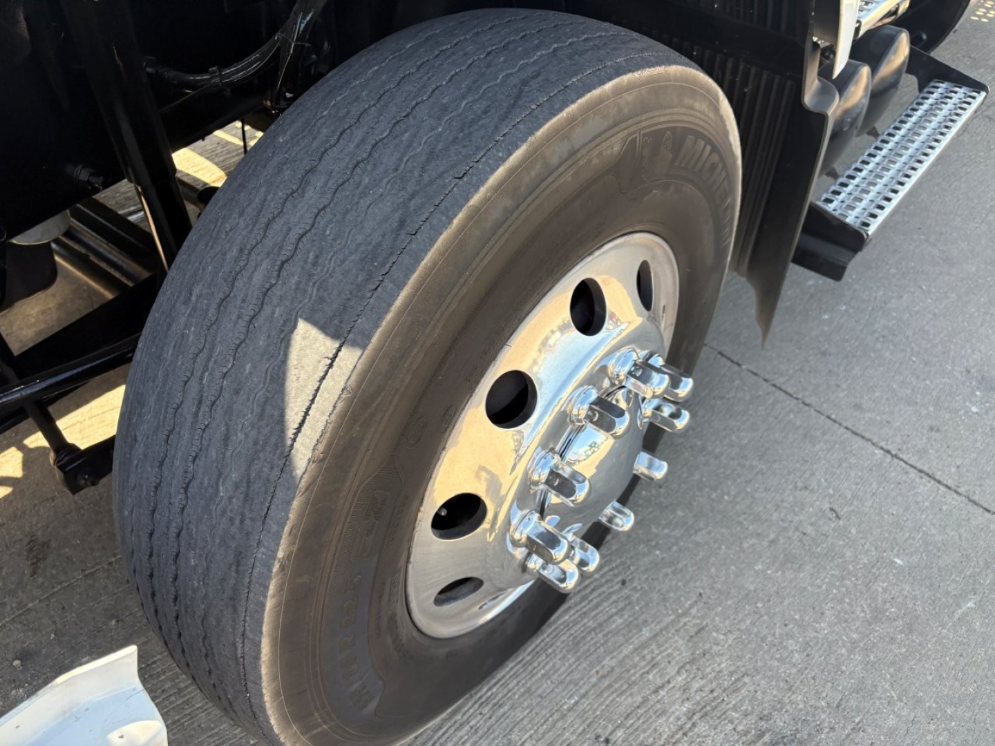 Truck front wheel and dual rear tires on a Volvo VNR64T660 showing rim and lug nuts.