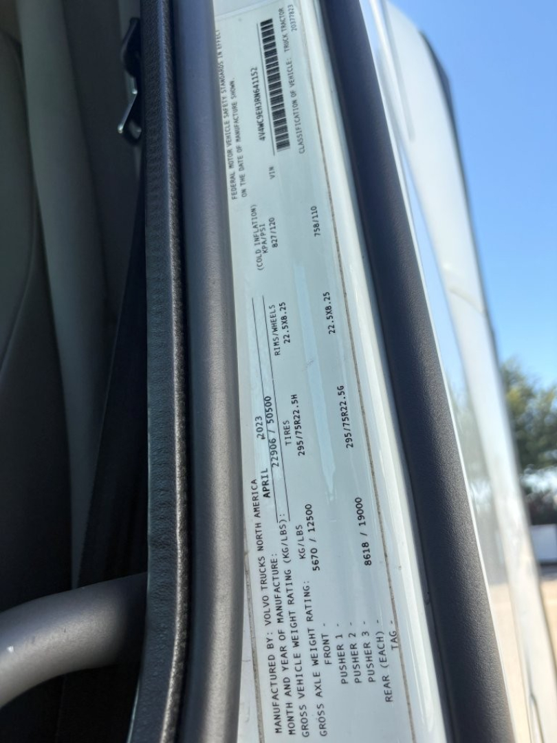 Vehicle information tag inside Volvo VNR window showing VIN, stock number, and axle weights and capacities.
