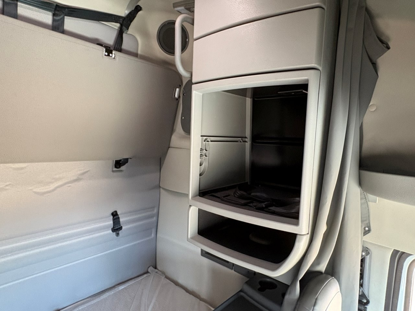 Volvo VNR64T660 sleeper truck interior showing open storage compartments and cab area with shelves.