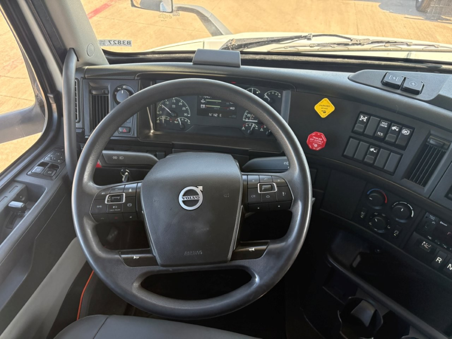 Volvo steering wheel and dashboard view inside a 2024 VNR64T660 truck cab showing steering wheel with Volvo logo, instrument cluster, and control panels.