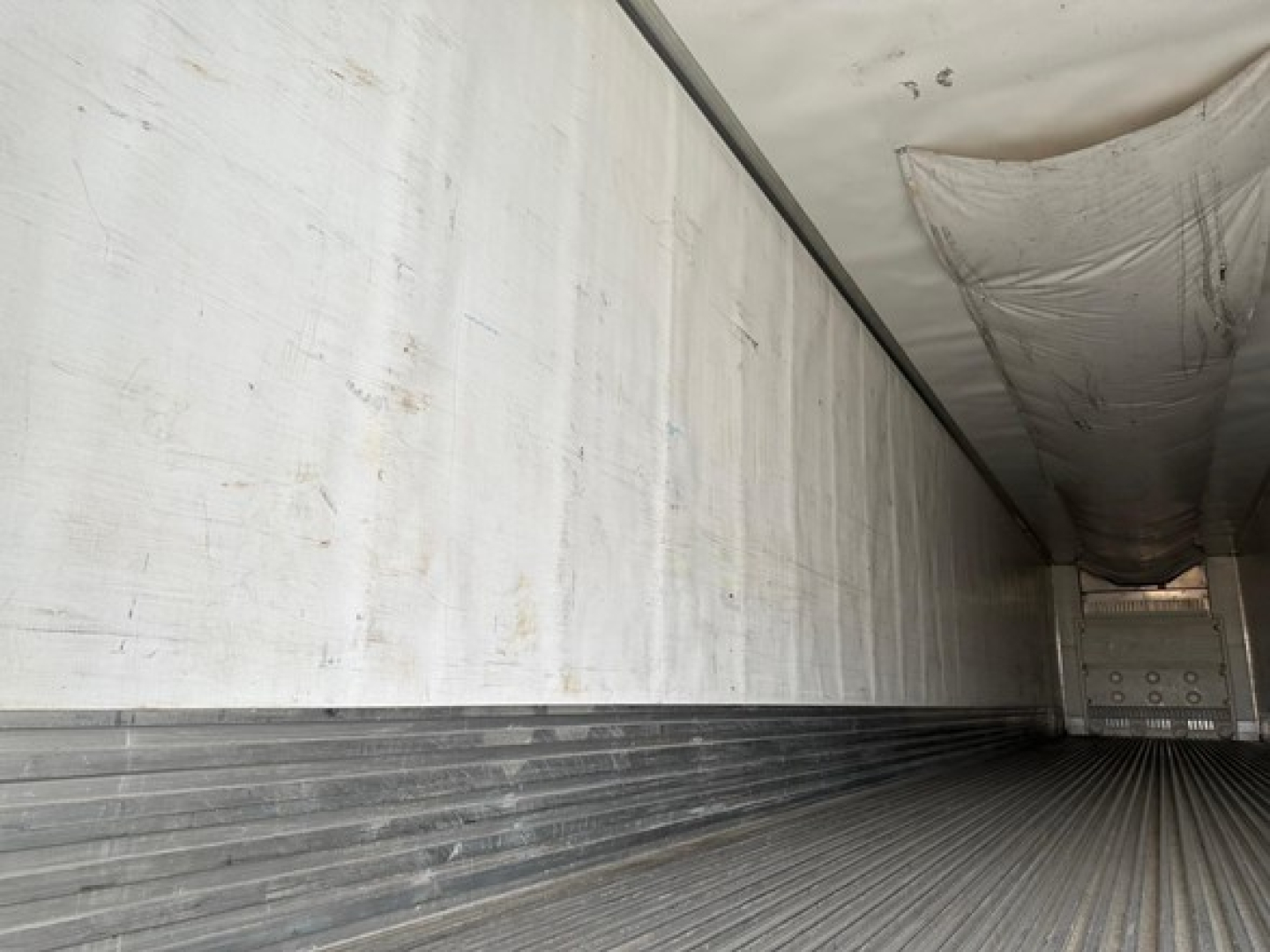 Interior of a 2023 Utility 3000R trailer cargo area showing ribbed floor and sidewall panels with interior at the rear door.