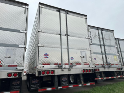 Rear view of a used 2023 Utility 3000R reefer trailer with diamond plate aluminum sides, dual rear doors, and John Deere style sticker; stock UE11058, VIN 150116362729.