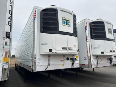 Utility 3000R trailer with Thermo King unit on front, white reefer trailer, two units visible in a lot, front facade shows cooling units and HT logo.