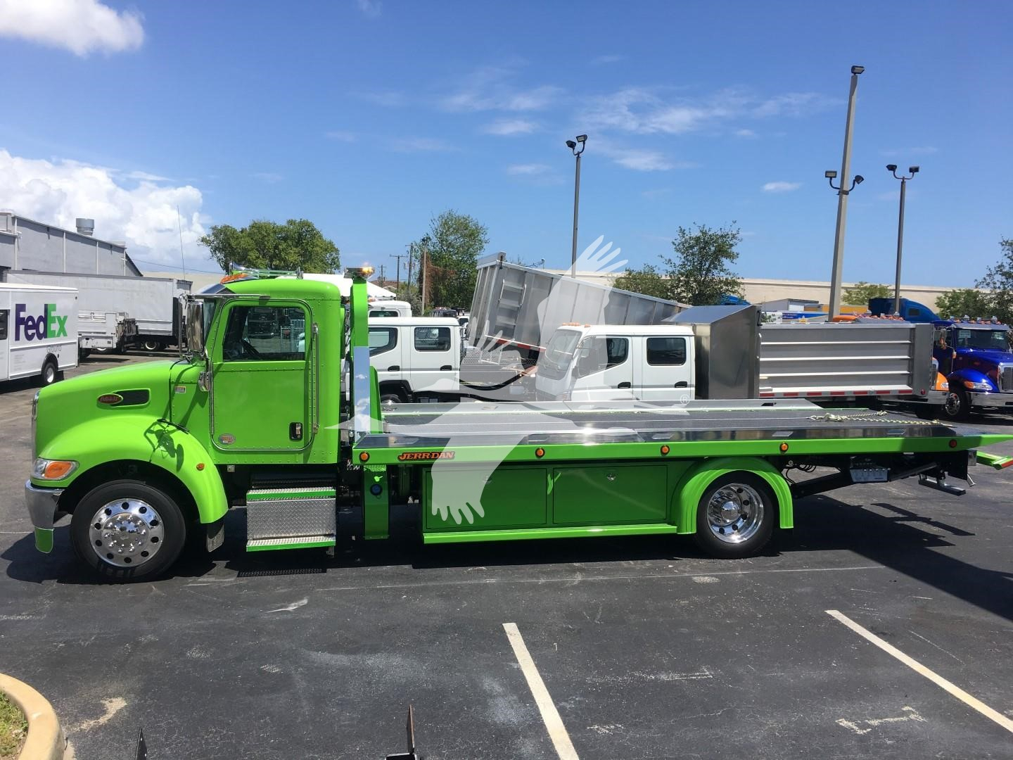 Green Peterbilt 337 rollback tow truck side view showing flatbed with chrome wheels and white graphic, stock J52310.