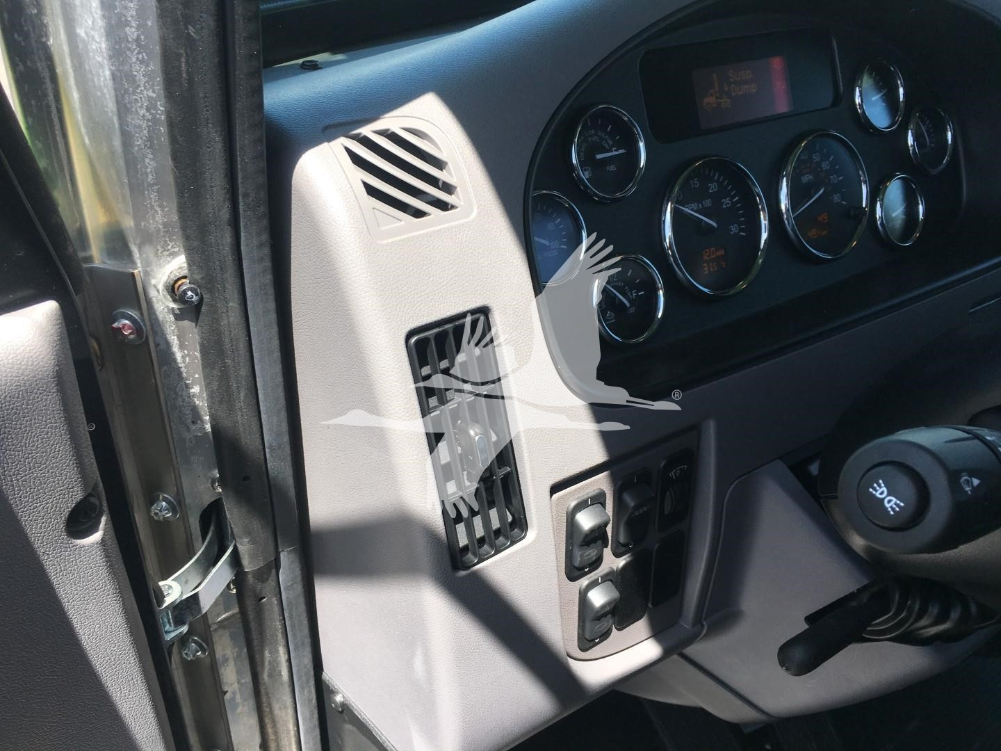Dashboard and driver-side door of a Peterbilt 337 truck showing gauges, ignition area, and control switches.