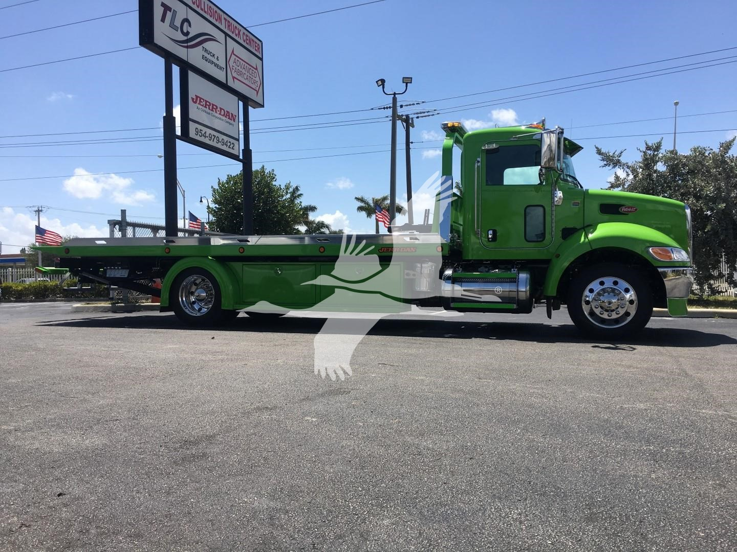 Green Peterbilt 337 rollback truck profile showing long flatbed and chrome wheels.