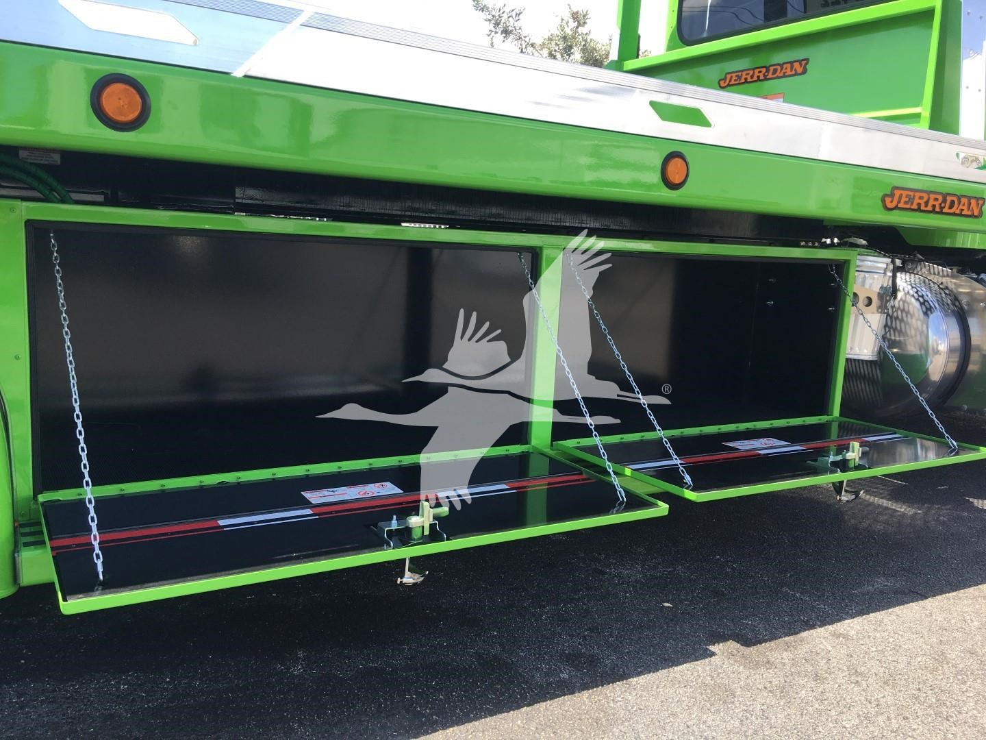 Peterbilt 337 rollback truck with open underbody compartment showing bright green exterior and black interior.