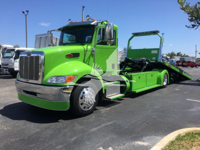 Green 2022 Peterbilt 337 rollback tow truck side view showing long wheelbase and flatbed with ramp, chrome bumper, large grille, and dual rear wheels.