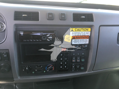 Peterbilt 337 dash area with radio in-dash stereo, climate controls, push buttons, and a caution sticker. Gear selector panel visible with P R N D.