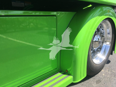 Peterbilt 337 rollback truck showing bright green fender with chrome wheel and white bird decal