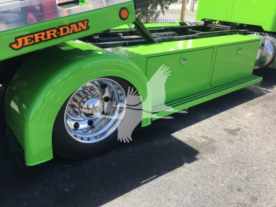 Green Peterbilt 337 rollback truck side view showing chrome wheel, green body panels, storage compartments, JERR-DAN branding, and visible wheel well.