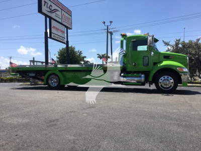 Green Peterbilt 337 rollback truck profile showing long flatbed and chrome wheels.