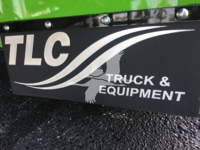 TLC Truck & Equipment plate on a green Peterbilt rollback truck showing TLC logo and text