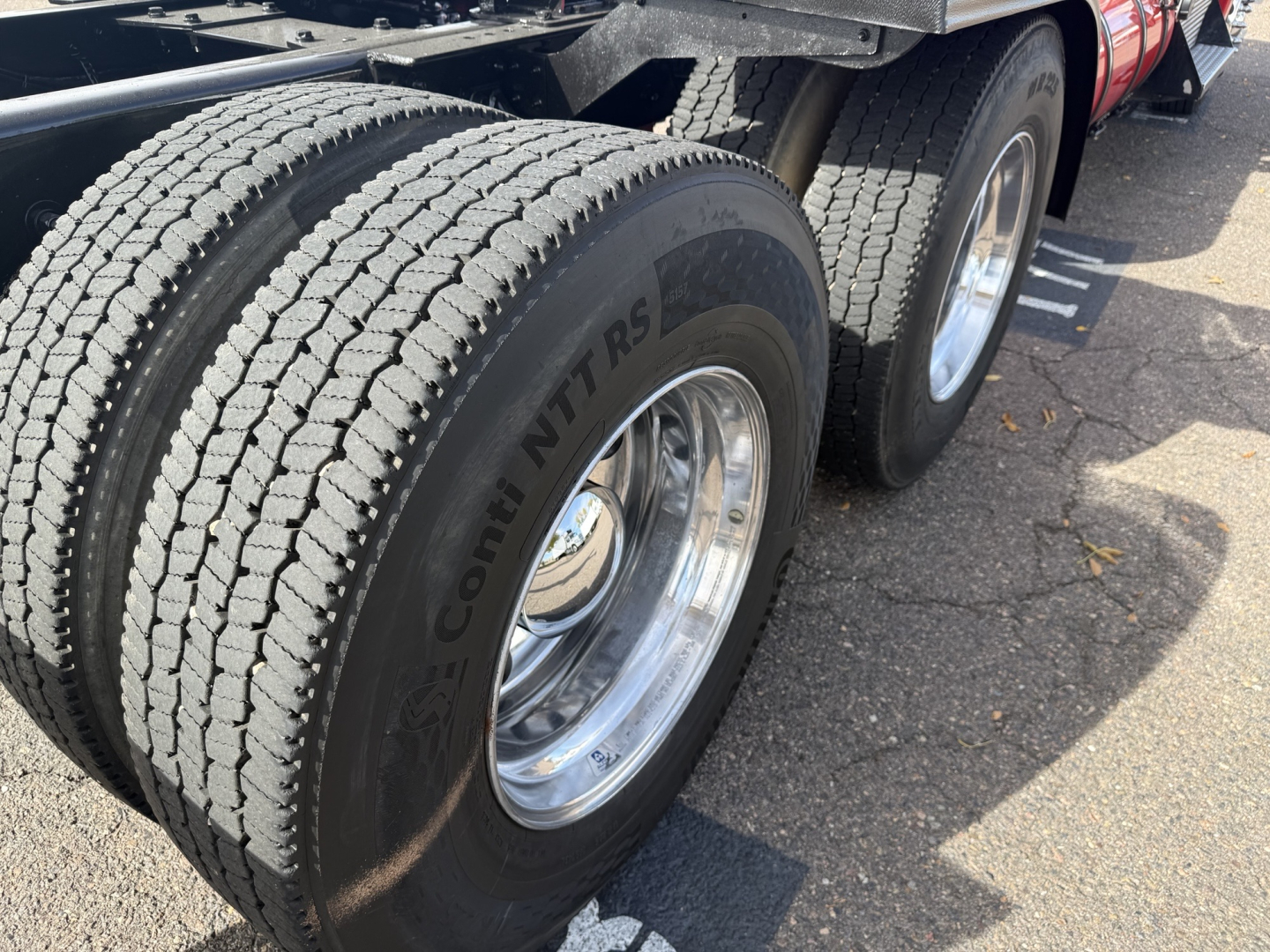 Kenworth T880 rear wheel area showing dual rear tires with ContiNT RS tire brand and chrome rims on a convention daycab truck.