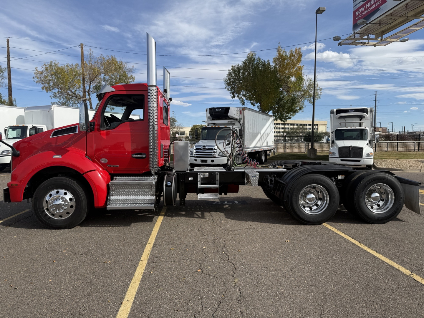 Red Kenworth T880 conventional daycab truck side profile with fuel tanks and chrome steps. Dual rear axles visible; there is a small front bumper and tall exhaust stack. The cab color is red with polished wheels.