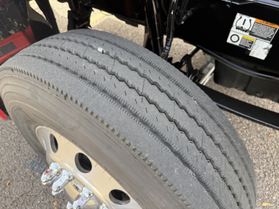Kenworth T880 front wheel and tire showing tire tread and front axle wheel with lug nuts and hub cover