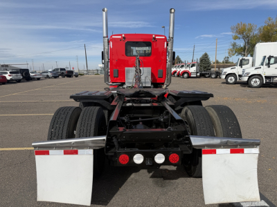 Truck chassis rear view showing dual rear axles, fifth wheel mounting, rear lights, and mud flaps on a Kenworth T880 daycab. VIN plate nearby and stock number 0632024 visible.