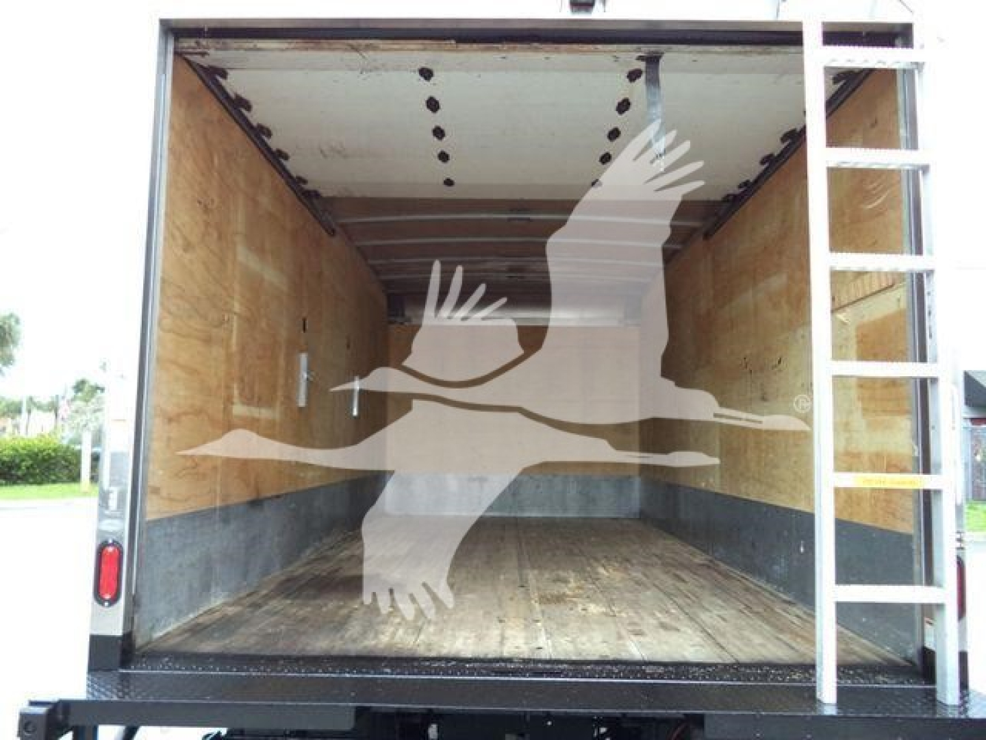 Isuzu NPR-HD box truck cargo area showing empty wooden walls and floor with a metal ladder to the right.