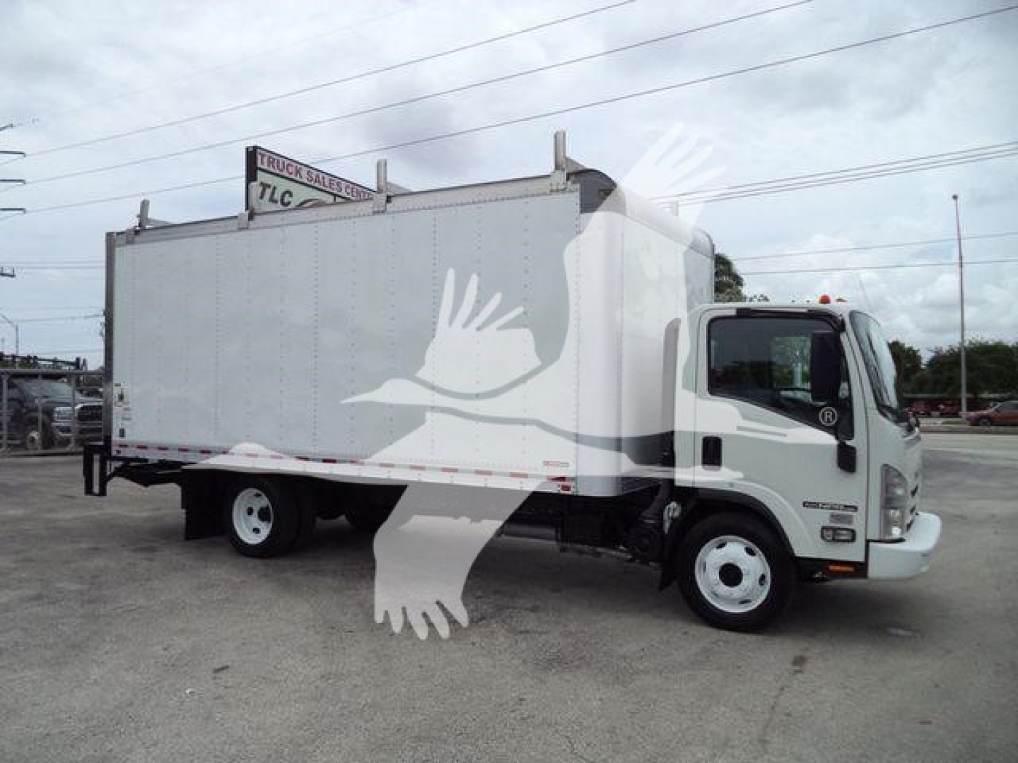 Isuzu NPR-HD box truck in profile showing cab and cargo area with blank side and front grille.