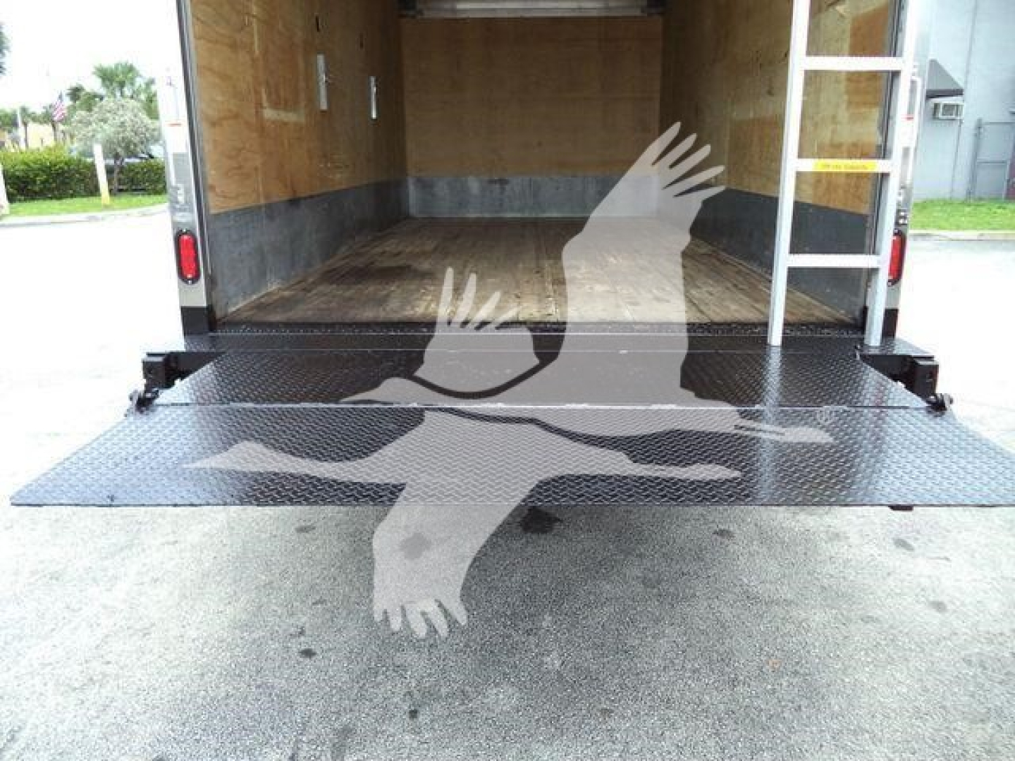 Isuzu NPR HD box truck rear cargo area with fold-down ramp and wooden interior