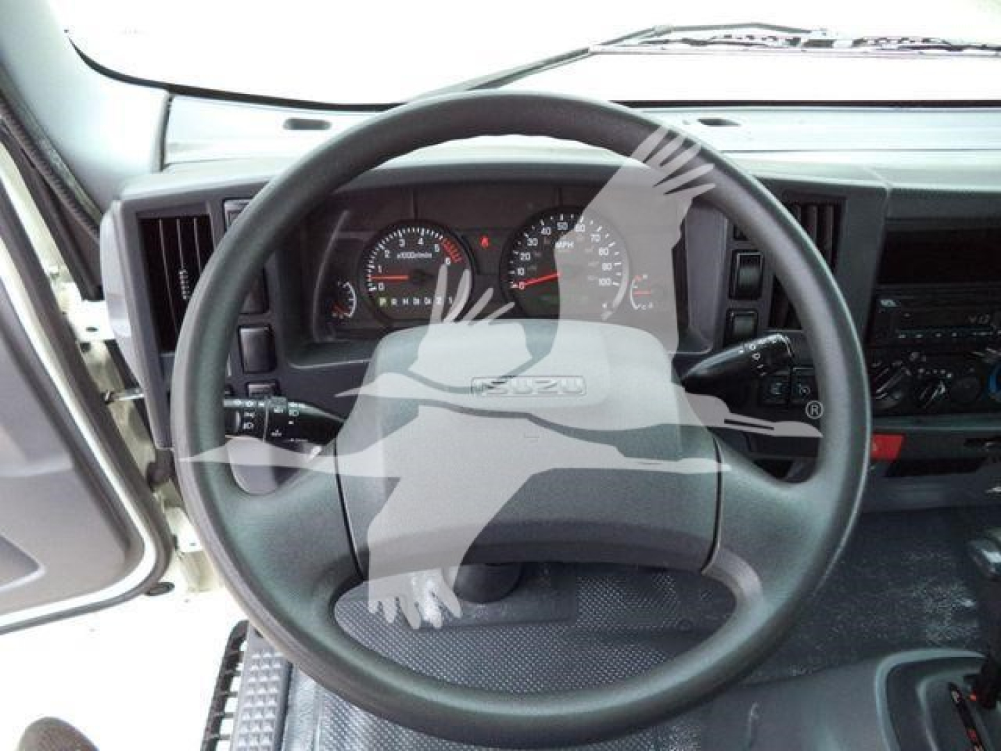 Isuzu NPR HD truck interior showing steering wheel and dashboard gauges.