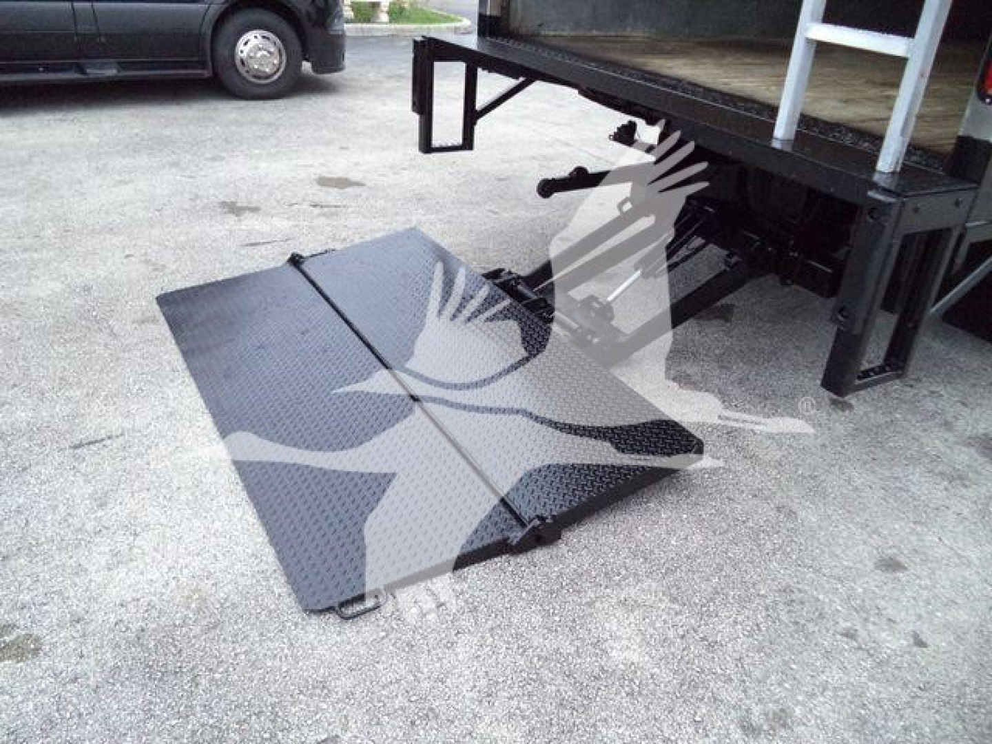 Isuzu NPR HD truck bed with lowered loading ramp and undercarriage visible.