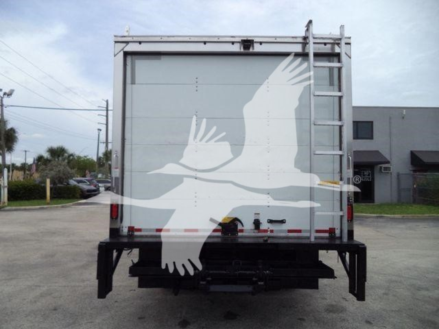 Isuzu NPRHD box truck rear view showing tailgate and undercarriage components.