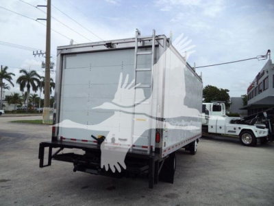 Isuzu NPR HD box truck rear view showing large enclosed cargo box with rear doors, ladder on right side, and stock watermark across image.