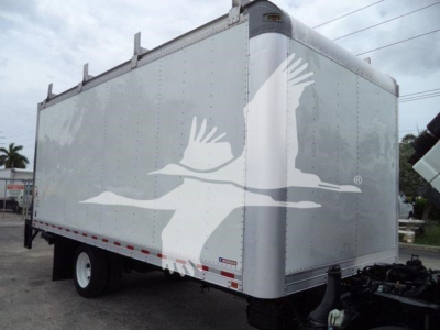 Isuzu NPR HD box truck trailer showing plain aluminum cargo body with logo silhouettes of flying birds on the side.