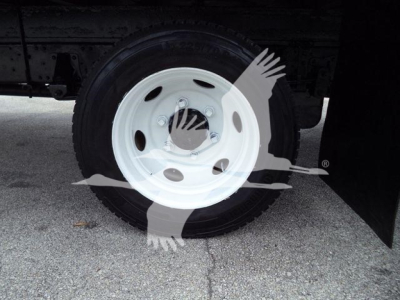 Isuzu NPR HD front wheel and fender area with white steel wheel and black tire; no visible text readable on components.
