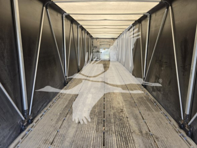 Trailer interior showing aluminum flatbed cargo area with side rails and wooden floor planks.