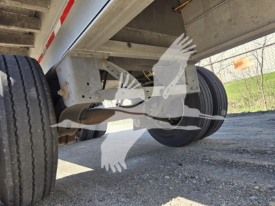 Trailer undercarriage showing dual tires and suspension on a 2023 Mac aluminum flatbed trailer
