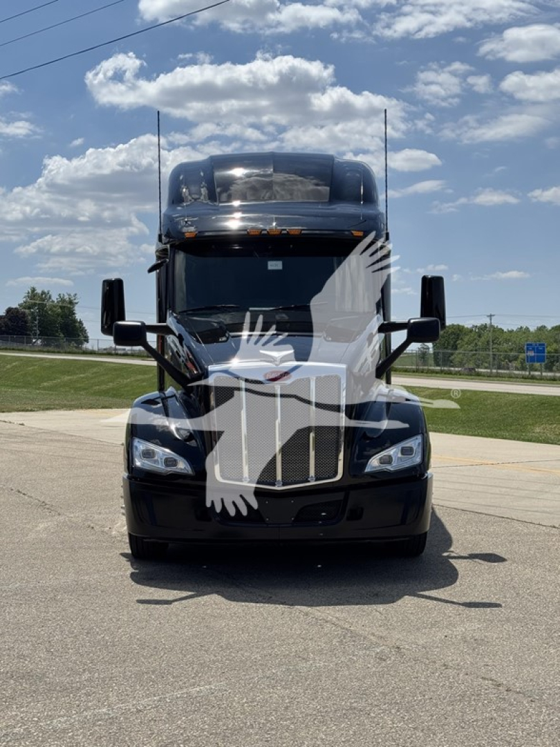 Peterbilt 579 conventional sleeper truck front view with black exterior and large grille.