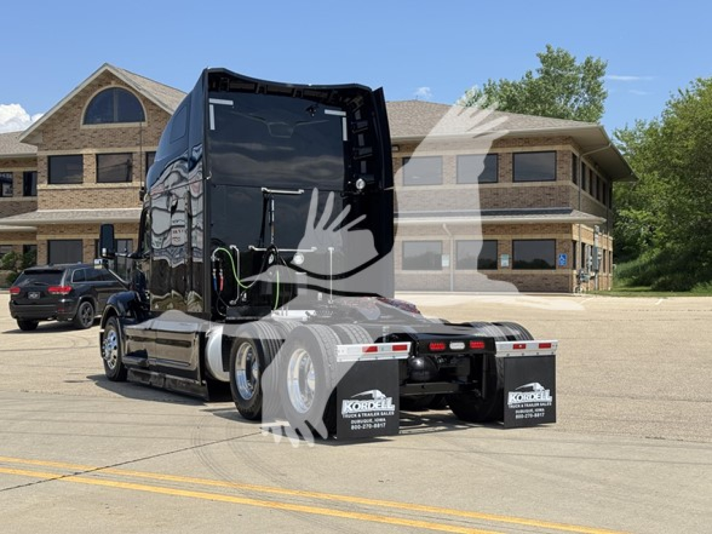 Peterbilt 579 tractor rear view showing sleeper and dual rear axles with mud flaps.