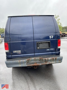 Ford E-350 cargo van rear view showing blue body, split rear doors, 350 emblem, 57 sticker, and rusted bumper.