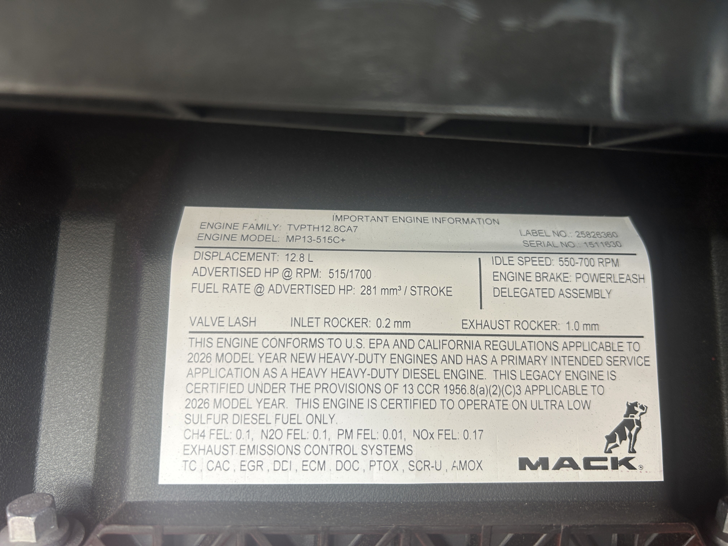 Engine information label on Mack AN64T showing engine model P0??8??? with details like displacement 12.8 L, idle speed 1500 RPM, fuel rate, exhaust, etc.