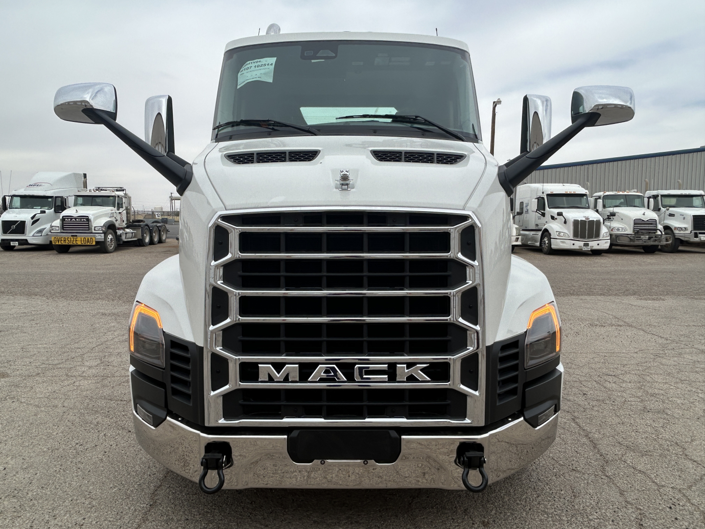 Front view of a white 2027 Mack AN64T conventional daycab truck showing prominent grille, chrome bumper, and large side mirrors.