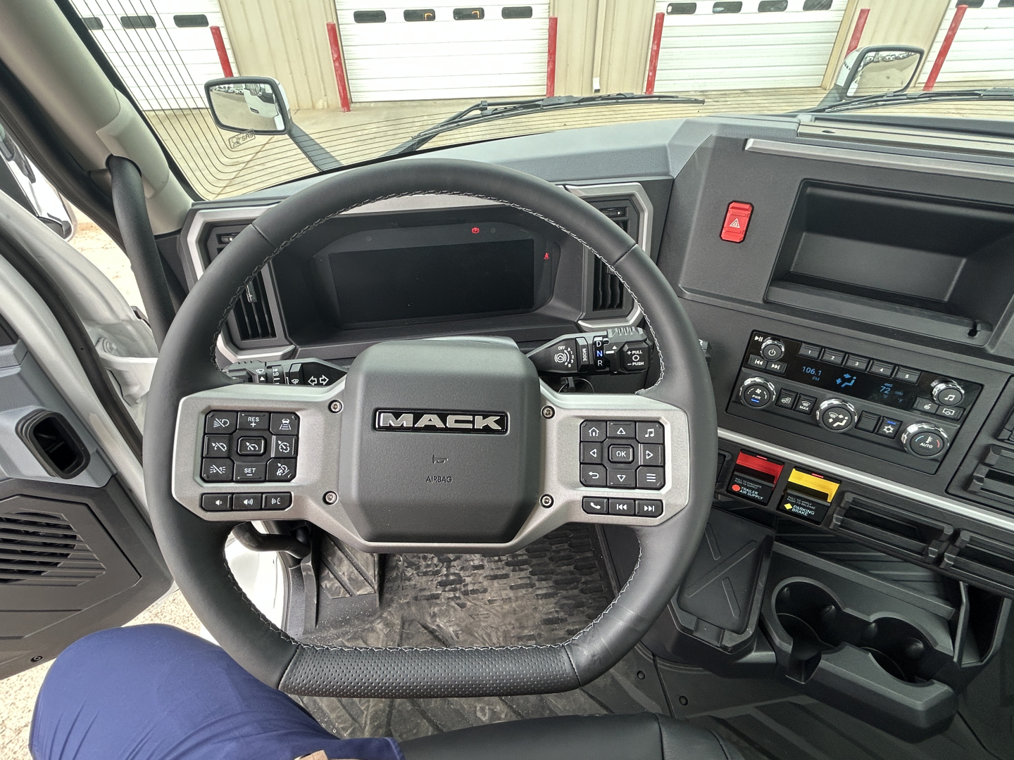 Mack AN64T truck interior dashboard and steering wheel with controls and center display.