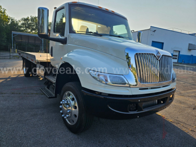 International MV607 tow truck front-left view showing chrome grille, dual rear wheels, and flatbed; VIN 1FVAG3DX4JHJL3327 visible; stock 3956-925.