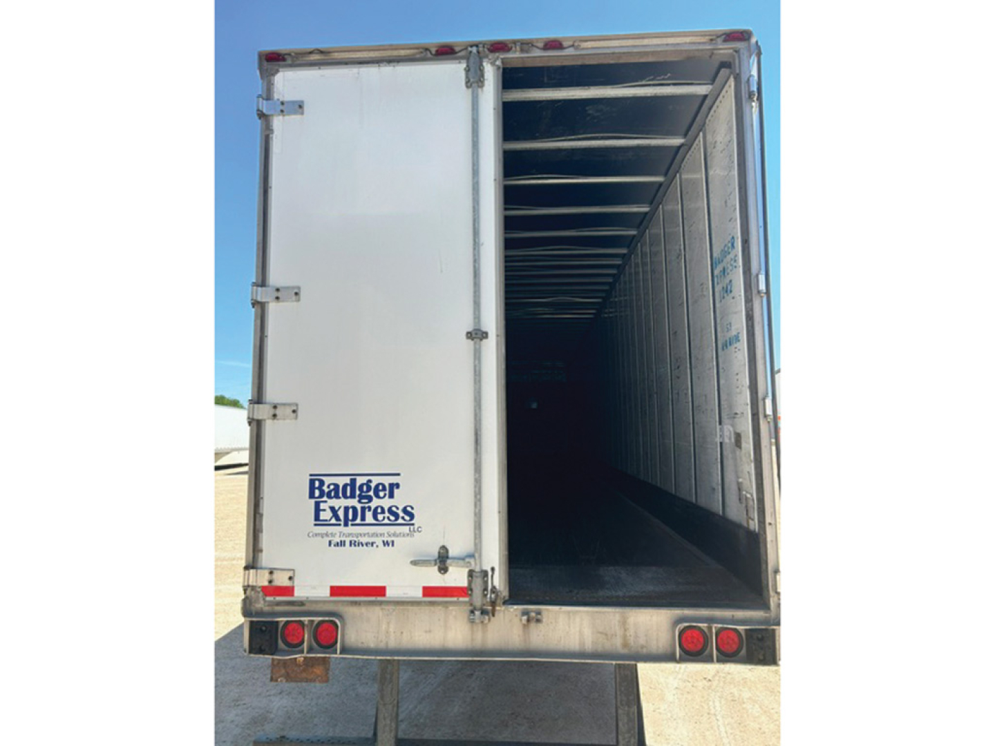 Rear and open cargo area of a 2005 Utility trailer showing empty interior and Badger Express branding on the tailgate.