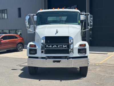Front view of a new white 2026 Mack MD7 hooklift truck showing large grille with MACK lettering, chrome bumper, and side mirrors.