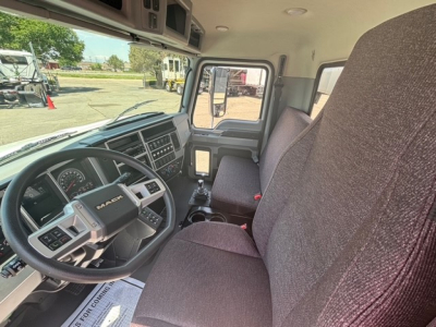 Interior of a new Mack MD7 hooklift truck showing steering wheel, dashboard, and front seats.