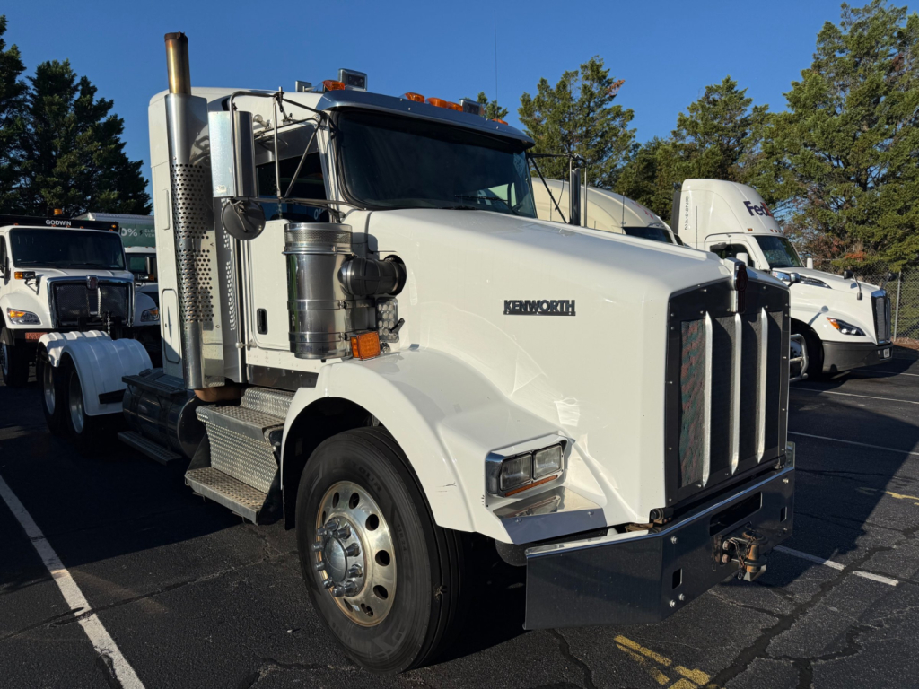 Kenworth T800 conventional sleeper truck in white, front view, with chrome grille and dual exhaust stacks.
