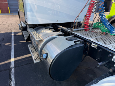 Truck fuel tank and side-view of chassis on a 2020 Kenworth T800 conventional sleeper, showing cylindrical fuel tank, metal steps, and color-coded air lines.