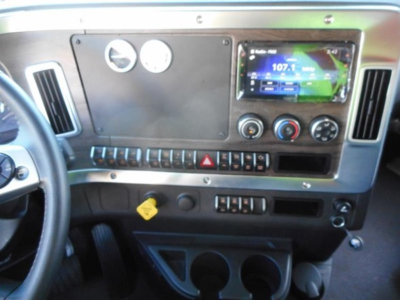 Truck dash panel showing Western Star 47X interior with touchscreen infotainment, round gauges, climate controls, and center console.