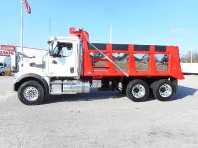 Dump truck showing white cab and red dump bed with three side panels and rear wheels visible.