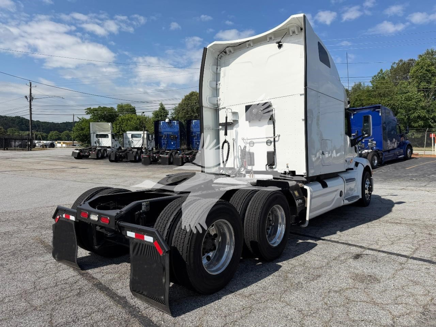 Peterbilt 579 conventional sleeper tractor rear/side view showing sixth wheel dual rear axle and sleeper cab, white exterior, yellow light color