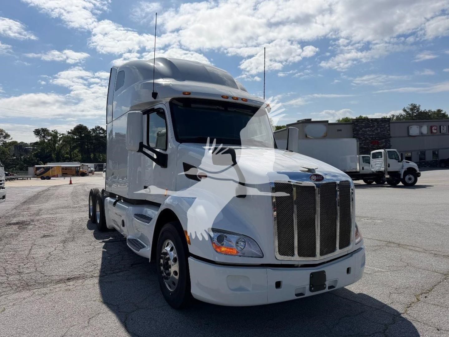 Peterbilt 579 cab over truck in a parking lot, white exterior, front grille, headlights, and sleeper cab visible.